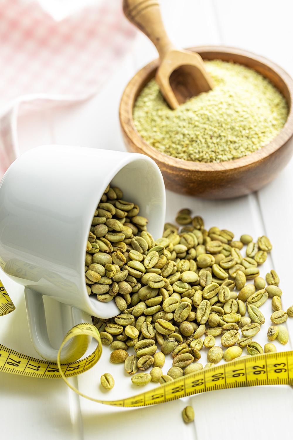 Unroasted green coffee beans on a white table.